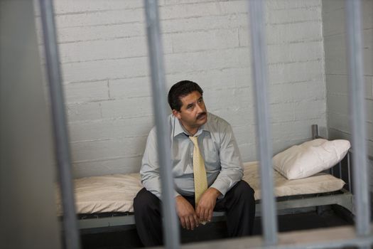 Criminal sitting on bed in jail