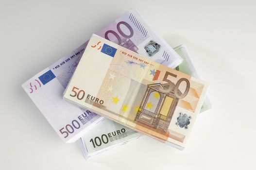 High angle view of stacked Euro notes isolated over white background