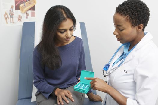 Female doctor passing medicine to patient