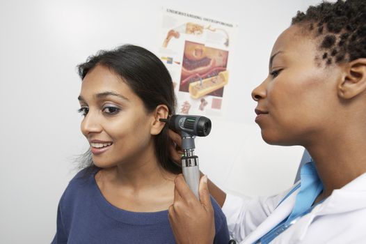 General practitioner using an otoscope to examine a patient's inner ear