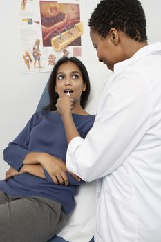 Female doctor examining an Indian patient's throat