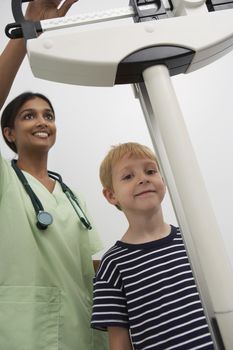 Female doctor weighting young patient