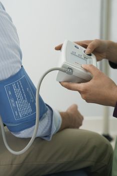 Doctor checking patients blood pressureclose-up