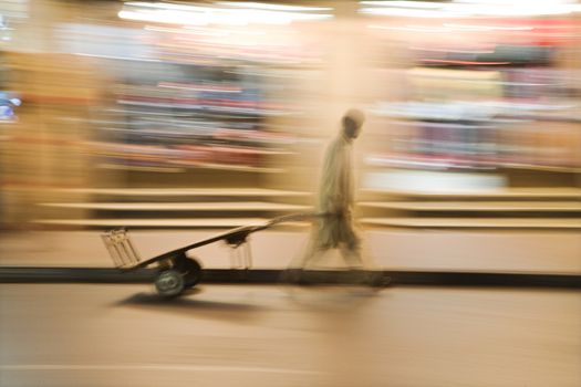 Dubai UAE A man wheels an empty cart through the streets of Deira just after dark.