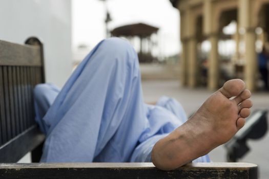 Dubai UAE man taking rest on park bench along boardwalk in Bur Dubai