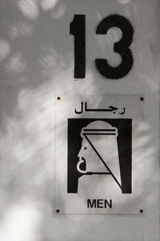 Closeup of men's restroom sign with number 13
