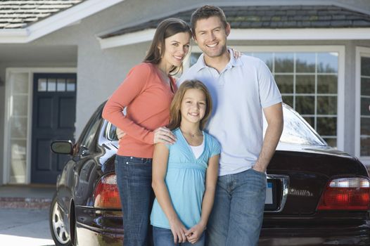 Family outside house with car