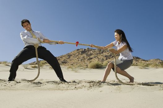 Two Business People Playing Tug of war in the Desert