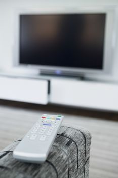 Closeup of a remote control with blurred television in the background
