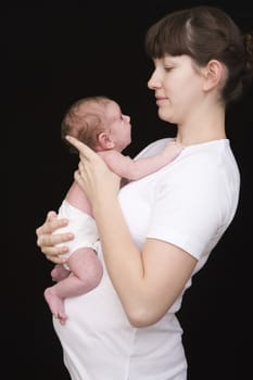Modern holding her newborn baby studio shot