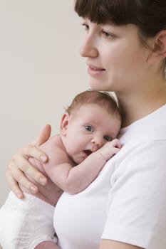 Portrait of mother hugging her newborn baby studio shot