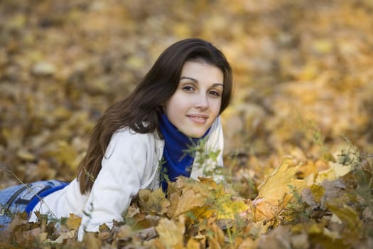 Woman lying on leaves in park