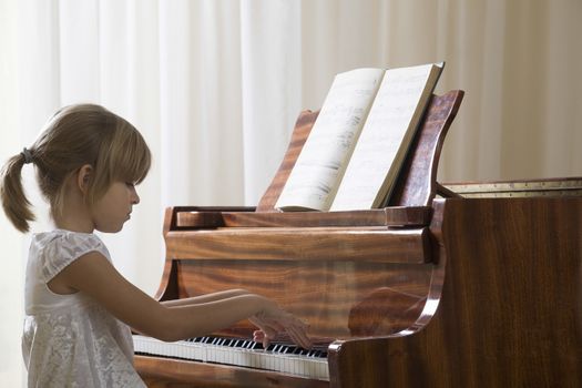 Girl (5-6) playing piano