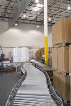 Cardboard boxes and conveyor belt in distribution warehouse
