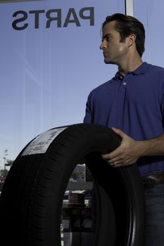 Side view of man holding tire
