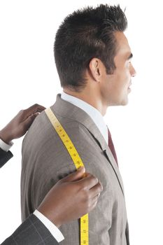 Tailor measuring across upper back from shoulder to shoulder of customer