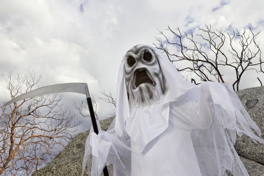 Boy dressed up as grim reaper holding scythe