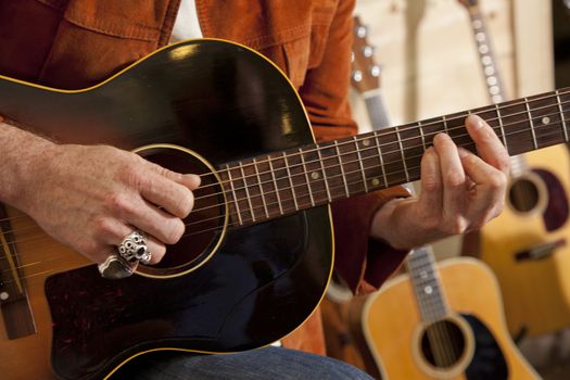 Close-up of man's torso practicing with guitar