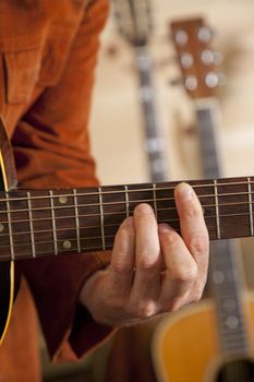 Close-up of mid adult man's fingers while playing guitar