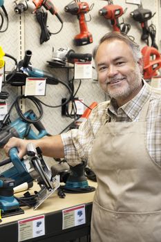 Portrait of a happy salesperson with electric saw in hardware store