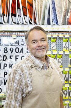 Portrait of a happy mature salesperson in hardware store