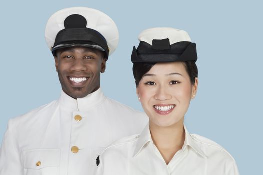 Portrait of multi-ethnic US Navy officers smiling over light blue background