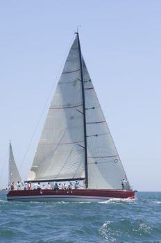 Triangular sail on yacht in competitive team sailing event California