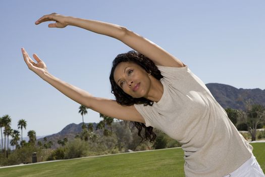 Mid adult woman stretching arms over head