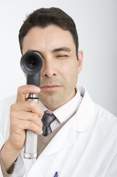 Optician looks through sight testing equipment