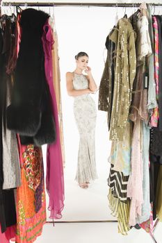 View through clothing rail of woman in long evening dress