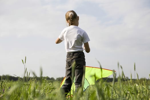 Young girl flying kite in field