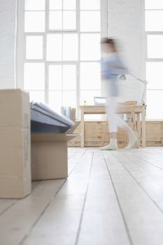 Woman walks across loft apartment blurred motion