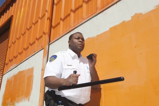 Armed security guard investigates warehouse exterior