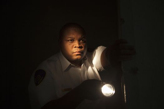 Security guard investigates with flashlight