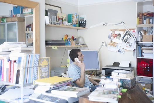 Creative professional sits on phone in corner of office