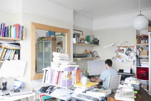Creative professional sits at computer in corner of office