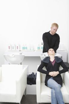 Female client has hair shampooed in salon basin