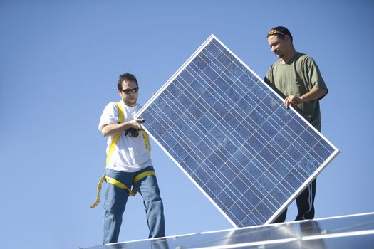 Two men lifting a solar panel