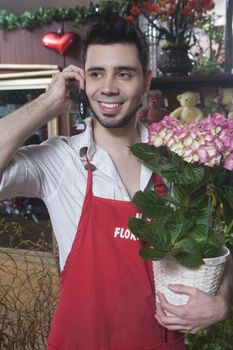Florist stands on mobile phone with  hydrangea