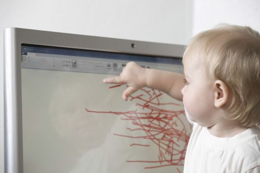 Child draws on computer with touch screen technology