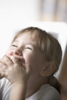 Girl laughing with hands over mouth