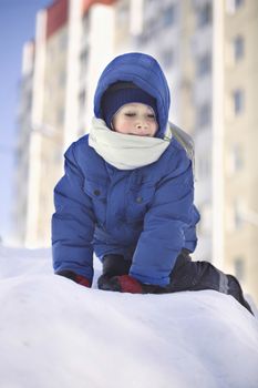Young boy climbing in the snow
