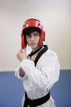 Teenage boy wearing martial arts headgear while looking away