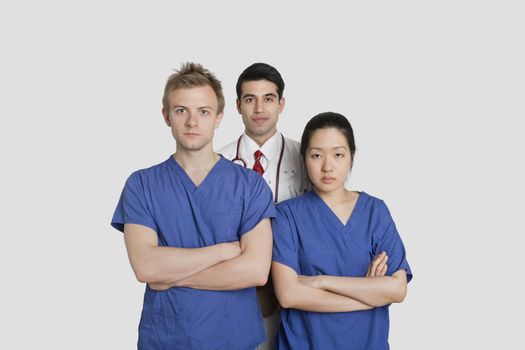 Portrait of confident healthcare workers standing over gray background