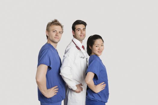 Portrait of medical team standing hands on hips over gray background