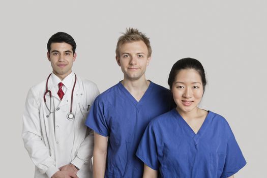 Portrait of happy medical team standing over gray background
