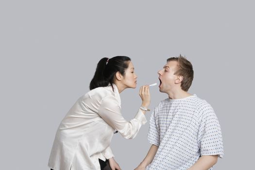 Female doctor examines patient's throat