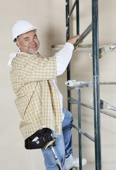 Portrait of a happy worker climbing scaffold