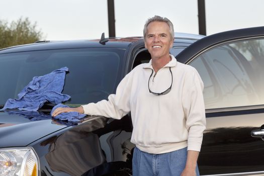 Portrait of mature man standing next to his car