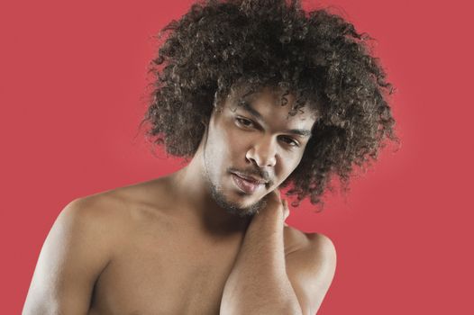 Portrait of a young man with curly hair over colored background